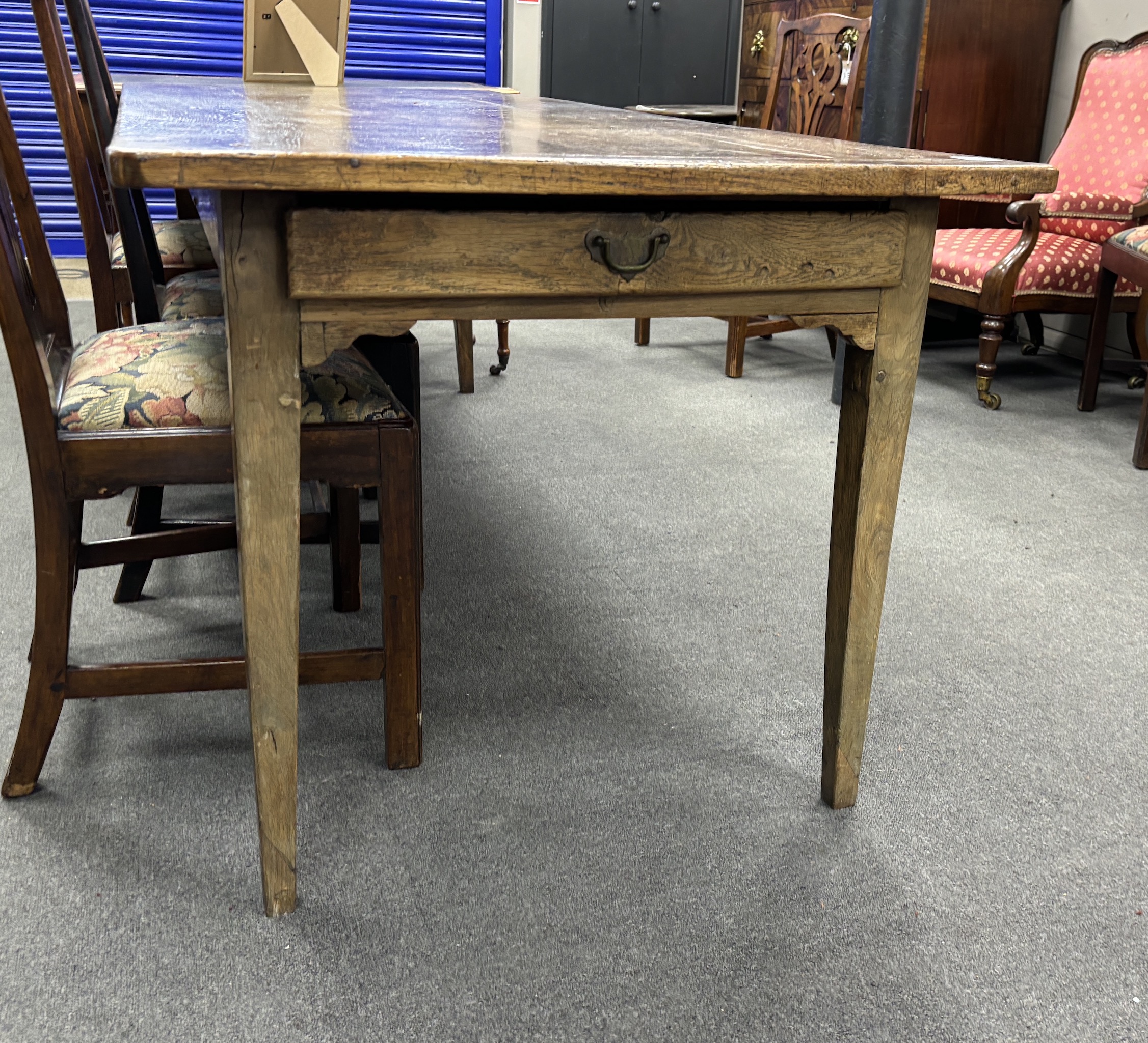 A 19th century rectangular Provincial oak kitchen table with cleated plank top, fitted two drawers on square tapered legs, width 220cm, depth 84cm, height 74cm